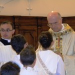 Il cardinale Bertone dà l'Eucarestia ai ragazzi della Prima Comunione